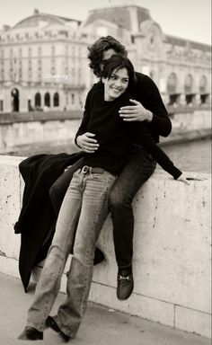 black and white photograph of two people sitting on a wall