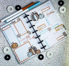 an open planner book sitting on top of a table next to some candles and buttons