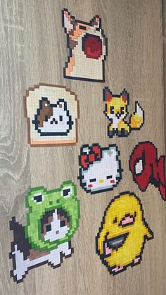 several pixelated stickers on a wooden surface