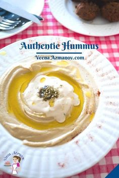 a plate with hummus on it sitting on a red and white checkered table cloth