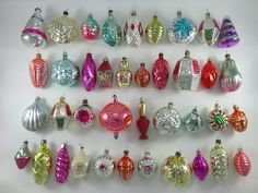 an assortment of christmas ornaments displayed on a white surface