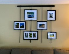 a living room with pictures hanging on the wall and a couch in front of it