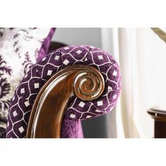 a close up of a chair with purple and white pillows