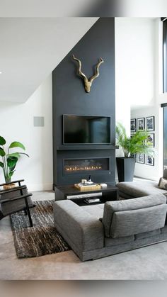 a living room with two couches and a television mounted to the side of a wall