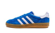 The adidas Gazelle Indoor “Blue Bird” is a vibrant blue colorway of the retro indoor soccer shoe by the German footwear company.  The classic silhouette’s suede upper is featured in a bright shade of blue that adidas has dubbed “Blue Bird. ” Contrasting white leather Three Stripes branding can be seen on each side.  A gold “Gazelle” logo appears on the lateral side of the shoe while classic adidas Trefoil detailing is seen on the heel.  More adidas branding is found on the tongue.  A semi-translucent gum rubber sole completes the look.  Release date: July 15, 2022 Adidas Shoes Gazelle, Bird Shoes, Adidas Gazelle Indoor, Nike X Travis Scott, Gold Adidas, Converse Run, Converse Run Star, Adidas Trefoil, Nike Dunk High