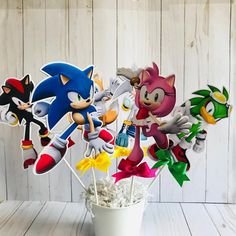 a cup full of cake toppers with sonic and tails on them