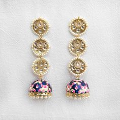 Accessorize your outfit with our cute navy blue Rasika jhumka earrings, a meenakari-style, hand-painted jhumka with embedded gemstones and pearls. Did you know that the word "rasika" means passionate in the Sanskrit language? Specifications Materials used: meenakari, jhumka, gemstones, pearls At Romikas, we pride ourselves on the craftsmanship and high quality of our jewelry, designed to enhance your natural beauty. Please contact us with any questions. Festive Blue Tilla Jhumkas, Blue Jhumkas For Festive Occasions, Blue Bollywood Meenakari Earrings, Blue Meenakari Earrings For Festive Season, Blue Meenakari Temple Jewelry Danglers, Blue Temple Jewelry Jhumkas For Festive Season, Blue Tilla Jhumkas For Festivals, Blue Jhumkas With Tilla For Festivals, Blue Meenakari Jhumkas As Gifts