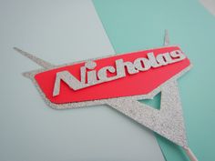 a red and silver sticker with the word nicholas on it's back side