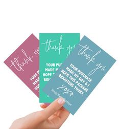 hand holding three thank cards with writing on them