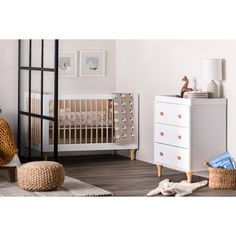 a baby's room with a crib and dresser