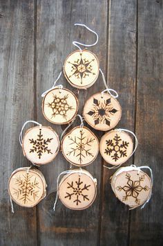 wooden ornaments with snowflakes hanging from strings