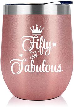 a pink wine cup with the words fifty and fabulous on it, in white lettering