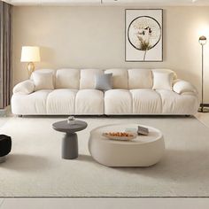 a living room filled with white furniture and decor on top of carpeted flooring