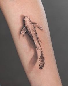 a small fish tattoo on the arm