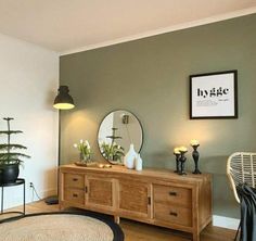 a living room with a rug, table and mirror on the wall in front of it