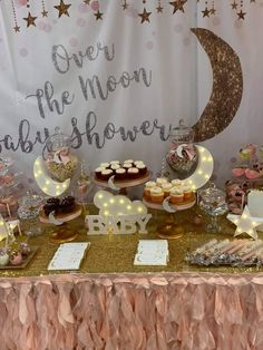 a baby shower table with cupcakes, cakes and desserts on the table