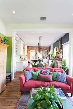 a living room filled with lots of furniture and plants on top of it's tables