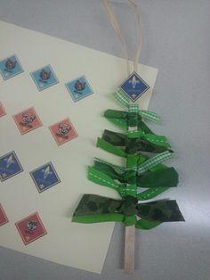 a christmas tree made out of stamps on a piece of white paper with green ribbon