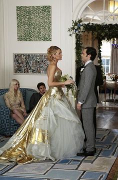 a woman in a wedding dress standing next to a man