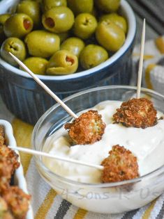 two bowls filled with appetizers and olives in the background