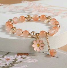 Introducing Our Stunning Peach Pink Color Flower Charm Glass Beaded Bracelet A Beautiful Accessory That Will Add A Touch Of Feminine Elegance To Any Outfit! This Bracelet Is Crafted With Care And Features Delicate Glass Beads In A Gorgeous Peach Pink Color That Exudes Softness And Sophistication. With Its Adjustable Length, This Bracelet Can Comfortably Fit Most Wrist Sizes. The Stretchy Band Ensures A Secure And Flexible Fit, Allowing You To Easily Slide It On And Off Without Any Hassle. The Fl Elegant Flower Crystal Bracelet For Spring, Elegant Flower Shaped Crystal Bracelet For Spring, Elegant Adjustable Crystal Bracelet For Spring, Elegant Flower Beaded Bracelets For Spring, Elegant Spring Flower Beaded Bracelets, Elegant Beaded Flower Bracelets For Spring, Spring Crystal Bracelet With Round Beads, Elegant Spring Bracelet With Colorful Beads, Pink Flower-shaped Beaded Crystal Bracelet