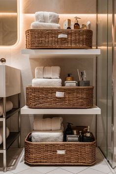 the bathroom shelves are organized with baskets and towels