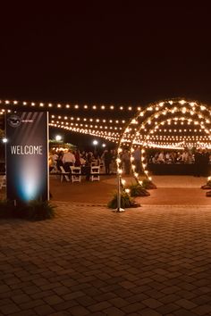 an outdoor event with lights on the walkway