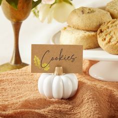 a table topped with cookies and white pumpkins