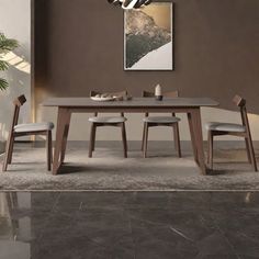 a dining room table and chairs in front of a brown wall with a painting on it