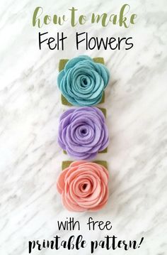 three felt flowers with free printable pattern on the bottom, and two different colors