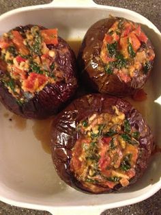 three stuffed mushrooms in a white dish with sauce