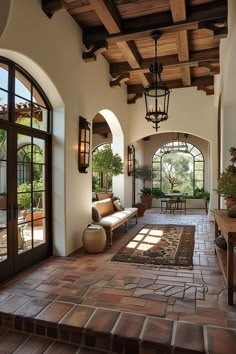 the inside of a house with lots of windows and wood beams on the ceiling, along with tile flooring