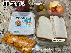 the lunch box contains two sandwiches, crackers and fruit on the counter top with text overlay that says chobani tuna