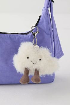 a small stuffed animal hanging from a purple purse