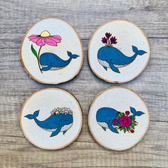 three blue whale coasters with flowers on them