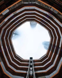 the inside of a building looking up at an escalator in the middle of it