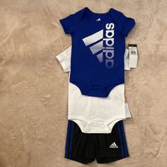 Adidas 3 Piece Outfit Size 9 Months. Outfit Includes: Two Short Sleeve Onesies And Shorts. One Blue Onesie, One White Onesie And Black Shorts. Brand New! Fitted White Adidas Sets, White Stretch Playwear Sets, Adidas Fitted Sets For Playwear, Adidas Fitted Playwear Sets, Sporty White Playtime Sets, Baby Boys Outfit, Toddler Adidas, Adidas Set, Adidas Baby