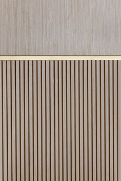 a wooden paneled wall with vertical lines on the bottom and gold trim around it