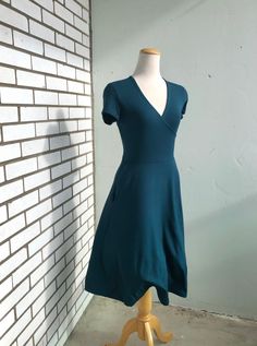 "This is the Classic Holloway dress, a half wrap bamboo rayon blend knit pullover dress. This is a faux wrap dress. The Classic Holloway features a wrapped bodice with a V-neckline, short sleeves (pictured in short sleeves, but also available in half sleeves or long sleeves), side seam pockets, a fitted bodice and an A-line skirt that falls just below the knee. It's made with spruce hued bamboo rayon fabric that is soft and very comfortable! Any custom fitting adjustment requests must be discuss Comfortable Bras, Knit Pullover, Everyday Dresses, Faux Wrap Dress, Fitted Bodice, Dress Clothes For Women, Fit And Flare Dress, A Line Skirt, Knitted Pullover