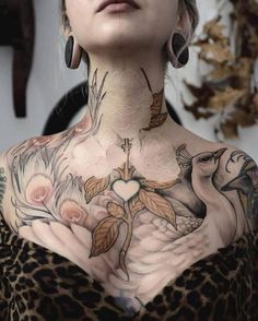 a woman with lots of tattoos on her body and chest is posing for the camera