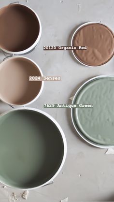 four different shades of paint sitting on top of a table next to each other in bowls