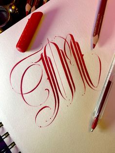 a pen and some ink on top of a piece of paper with the word mom written in cursive writing