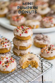 mini pumpkin donuts with frosting and sprinkles on a cooling rack