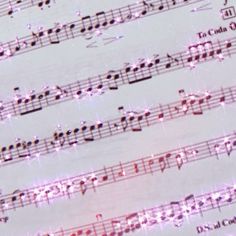 sheet music with pink and purple lights on it's notes in the foreground