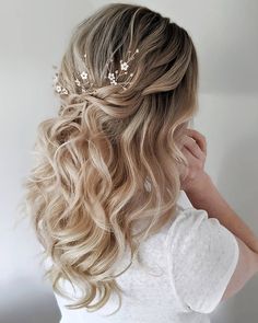 the back of a woman's head with blonde hair and flowers in her hair