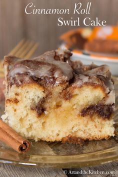 a piece of cinnamon roll swirl cake on a plate with cinnamon sticks next to it