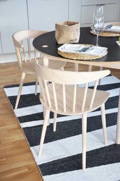 a kitchen table with chairs around it on a rug in front of the counter top