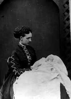 an old black and white photo of a woman holding a piece of cloth in her hands