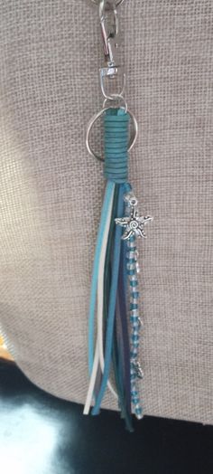 a keychain with a starfish charm hanging from it's center loop