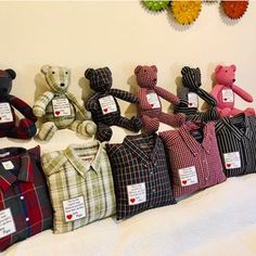 stuffed teddy bears are lined up next to each other on a white sheeted bed